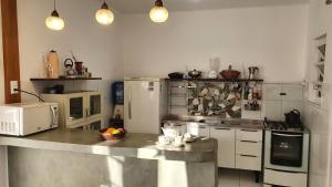 Casa da vovó Alba في بورتو أليغري: مطبخ مع كونتر مع ميكروويف وأجهزة