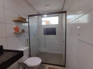 a bathroom with a toilet and a glass shower at Chaleville 2301, Praia do maramar, luis correia in Luis Correia