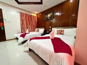 1 dormitorio con 2 camas con sábanas rojas y blancas en Mariafe Inn, en Puerto Princesa City