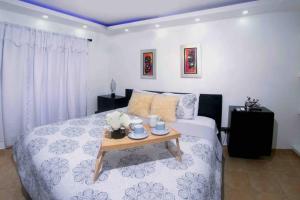a bedroom with a bed with a table on it at MODERN 3 BDRM KING BED 2BATHRM HOT WATER WIFI in Santo Domingo