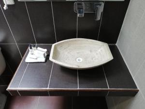 a bathroom with a sink on a black counter at CORDIALITY INN in Puebla
