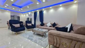 een woonkamer met een bank, stoelen en een tafel bij شقق مفروشه تشطيب مودرن علي النيل in Caïro