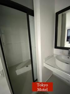 baño con puerta de ducha de cristal y lavamanos en Tokyo Motel en San Bernabé Amaxac de Guerrero