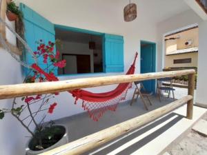 a balcony of a house with a hammock on it at Flats Lages in Pôrto de Pedras