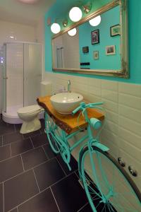 a bathroom with a sink and a bike on a counter at Apartments Elda in Makarska