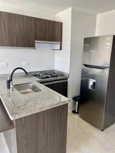 a kitchen with a sink and a refrigerator at Santorini Elite in Pereira