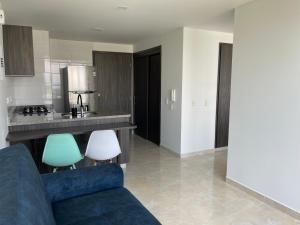 a living room with a blue couch and a kitchen at Santorini Elite in Pereira