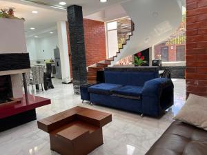 sala de estar con sofá azul y escalera en Casa vacacional con piscina 