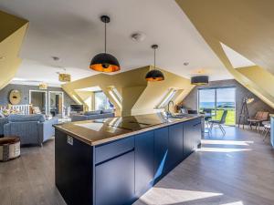 an open kitchen and living room with blue cabinets at Murlin in Collieston