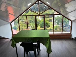 una habitación con una mesa verde y sillas en una tienda de campaña en Casa vacacional con piscina 