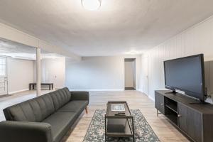 a living room with a couch and a flat screen tv at Centrally Located Basement Studio 