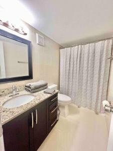 a bathroom with a sink and a toilet and a mirror at Lovely 2/2 condo in Miami shores in Miami