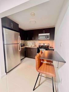 a kitchen with a table and a stainless steel refrigerator at Lovely 2/2 condo in Miami shores in Miami