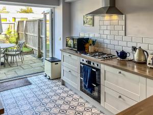 a kitchen with a stove top oven next to a patio at 8 Old School Mews in Shanklin
