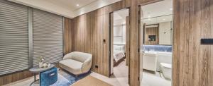 baño con silla blanca y lavamanos en The Stellar, en Hong Kong