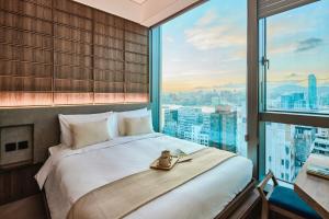 Un dormitorio con una cama grande y una ventana grande. en The Stellar, en Hong Kong