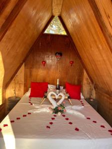 Un dormitorio con una cama con un corazón hecho de rosas en Ecocampingdage, en Catimbau