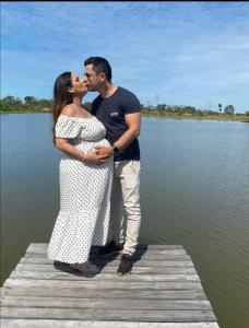 Ein Mann und eine Frau küssen sich auf einem Dock in der Unterkunft ESPACO LEÃO EVENTOS, Chácara para eventos, lazer ou descanso in Rio Branco