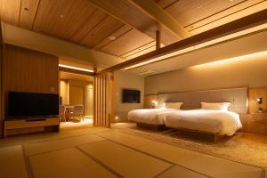 a bedroom with a large bed and a flat screen tv at Biwafront Hikone in Hikone