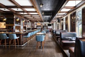 un restaurante con un bar con sillas azules en Four Points by Sheraton Victoria Gateway, en Victoria