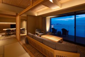 Biwafront Hikone في هيكونا: غرفة معيشة مع أريكة وإطلالة على المحيط