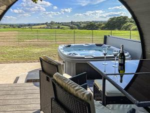 a hot tub on a deck with a table and two wine glasses at Barrow View - Uk43775 in South Barrow