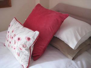 two red and white pillows sitting on a bed at The Granary in Burscough