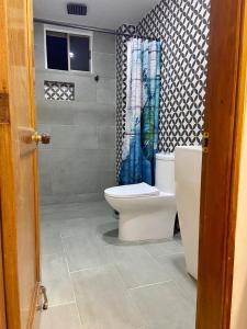 a bathroom with a toilet and a shower curtain at Espectacular vista a la playa el Rodadero in Santa Marta