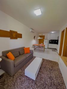 拉巴拉德納聖米格爾的住宿－Apê Laranja Iloa Barra de São Miguel，客厅配有沙发和桌子
