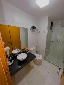uma casa de banho com um lavatório, um chuveiro e um WC. em Apê Laranja Iloa Barra de São Miguel em Barra de São Miguel