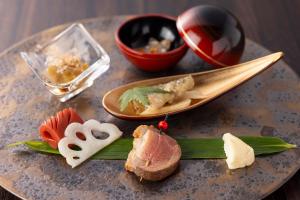 um prato de alimentos com carne e legumes sobre uma mesa em Biwafront Hikone em Hikone