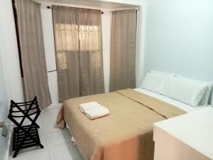 a bedroom with a bed with two towels on it at Larot's Vacation House - Rooms Only in Siquijor