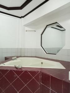 a bath tub in a bathroom with a mirror at Larot's Vacation House - Rooms Only in Siquijor