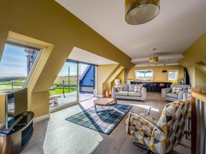 a living room with yellow walls and a large window at Murlin in Collieston