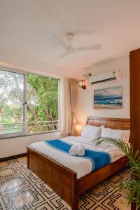 um quarto com uma cama e uma grande janela em HideAway 1BHK, Parra, North Goa (STU) em