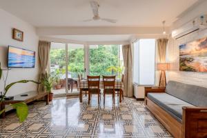a living room with a couch and a table and chairs at HideAway 1BHK, Parra, North Goa (STU) in Old Goa