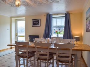 a dining room with a wooden table and chairs at Penrhiw Meredith in Llanfynydd
