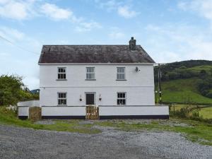 een wit huis op een heuvel bij Penrhiw Meredith in Llanfynydd