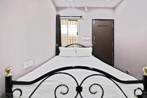 a black and white bed in a room with a window at SPOT ON Krishnaa Comforts Near Cubbon Park in Bangalore