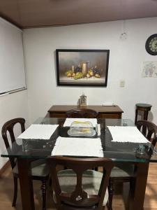 a dining room table with chairs and a painting on the wall at APTO DOS ALCOBAS MESETA in Bucaramanga
