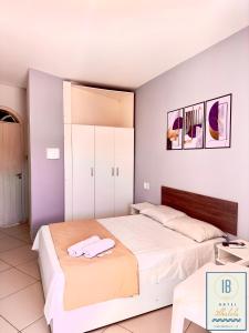 two beds in a bedroom with white walls at Hotel Residencial Ilhabela in Florianópolis