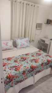 - une chambre avec un lit et une couette à fleurs dans l'établissement Aconchegante e especial, à Récife