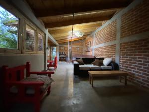 a living room with a couch and a brick wall at Rossco Backpackers Hostel in San Cristóbal de Las Casas