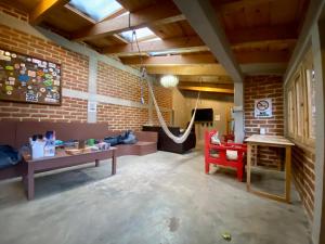 a living room with a brick wall and a hammock at Rossco Backpackers Hostel in San Cristóbal de Las Casas