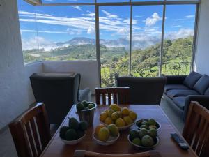 uma sala de jantar com uma mesa com taças de fruta em Bello Horizonte by JericóHouse 2 em Jericó