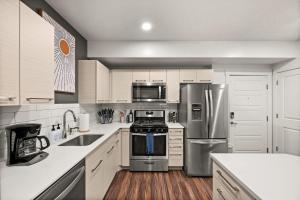 a kitchen with white cabinets and stainless steel appliances at Urban Adventure Awaits Near Everything in Salt Lake City