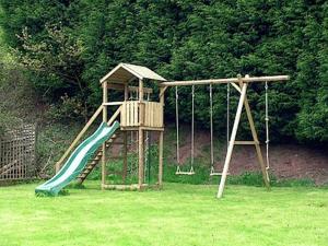 un parque infantil con un tobogán en un patio en The Stables Trap Farm, en Wolves Newton