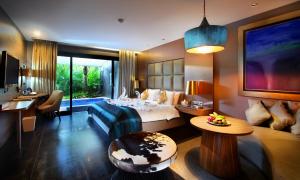 努沙杜瓦Amaroossa Suite Bali的配有床和书桌的酒店房间