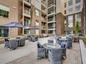 an outdoor patio with tables and chairs and umbrellas at Sleek & Stylish Salt Lake City APT Prime Loc in Salt Lake City