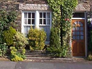 a brick house with a door and a porch at Alexandra Cottage in Windermere
